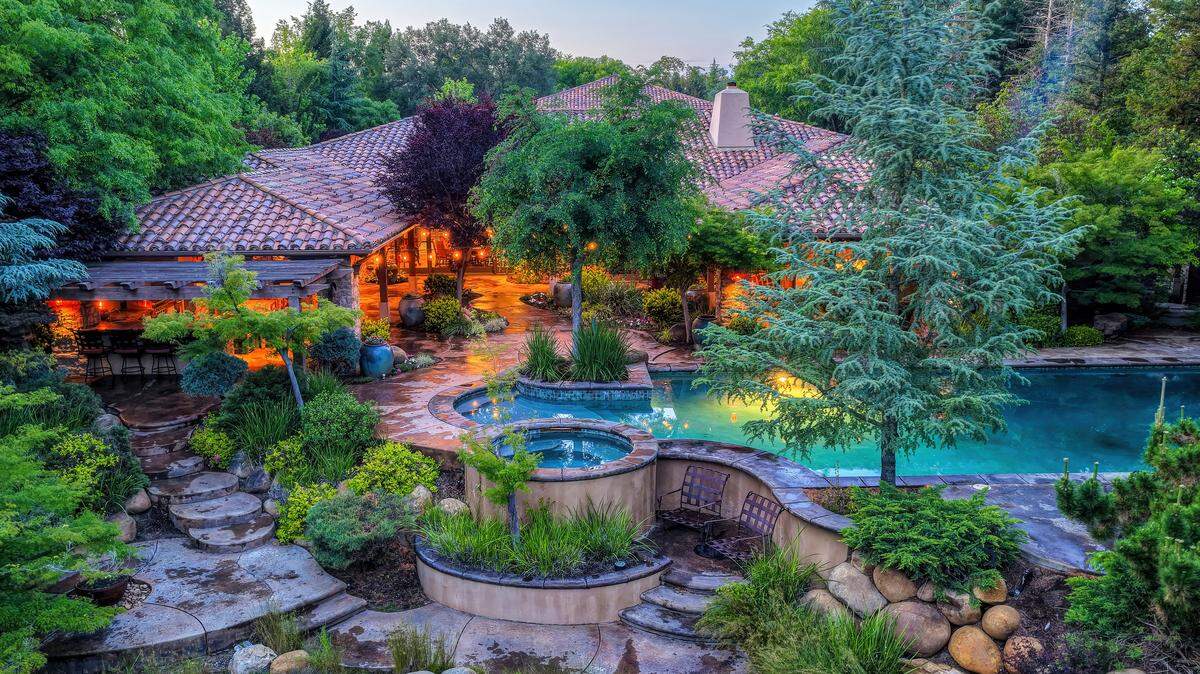 A sprawling pool, outdoor kitchen and garden beds anchor the backyard at 5183 Chelshire Downs Road in Granite Bay. 
