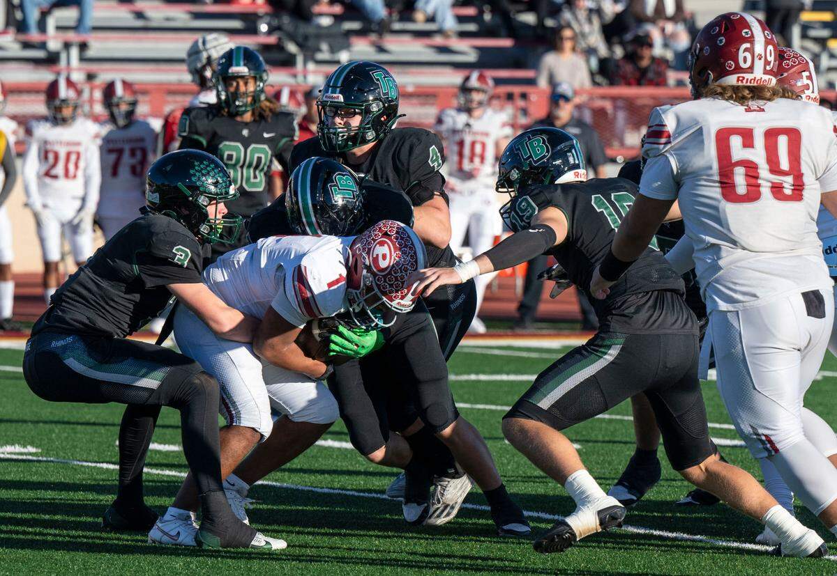 Twelve Bridges Raging Rhinos’ Jameson Elmer (3) and his teammates stop Patterson Tigers’ Jeremiah Lugo (1) at the line of scrimmage during the Sac-Joaquin Section Division IV championship game at Hughes Stadium in Sacramento on Friday, Nov. 29, 2024.