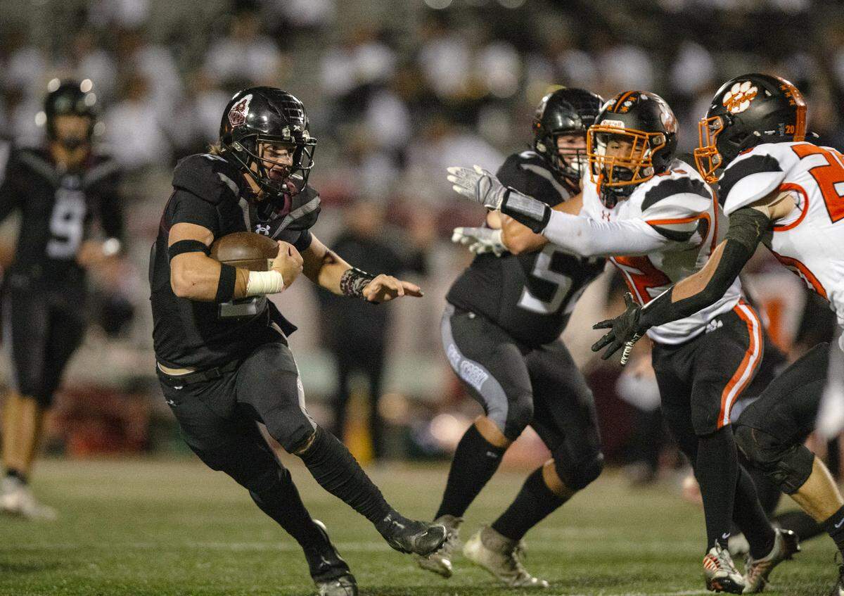 Woodcreek Timberwolves running back Brody Krupp (2) evades Roseville Tigers defenders Martin Williams (82) and Kaiden Pedone (20) on his way to a 27-yard touchdown in the second quarter on Friday, Oct. 27, 2023.