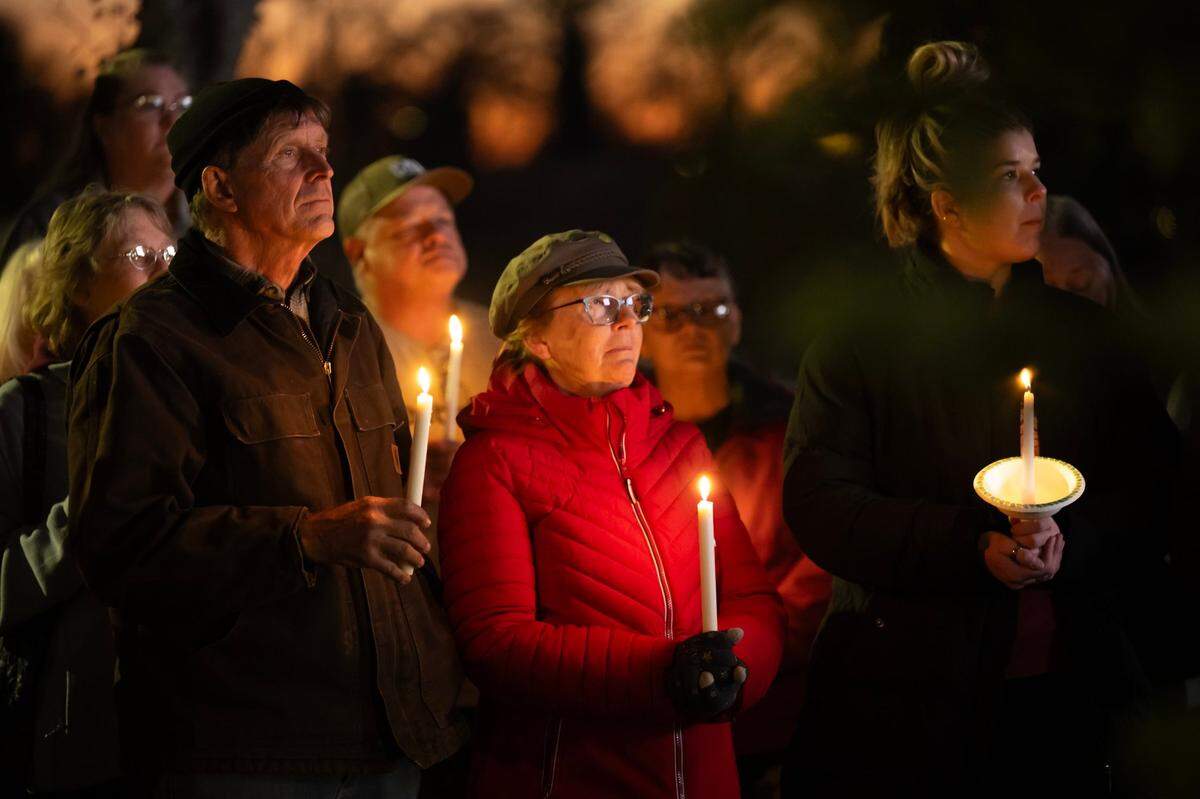 David and Karen Vixie and Kelsey Dillard hold candles at a vigil in downtown Oroville on Friday for the two boys who were injured in a shooting at Feather River Adventist School earlier in the week.