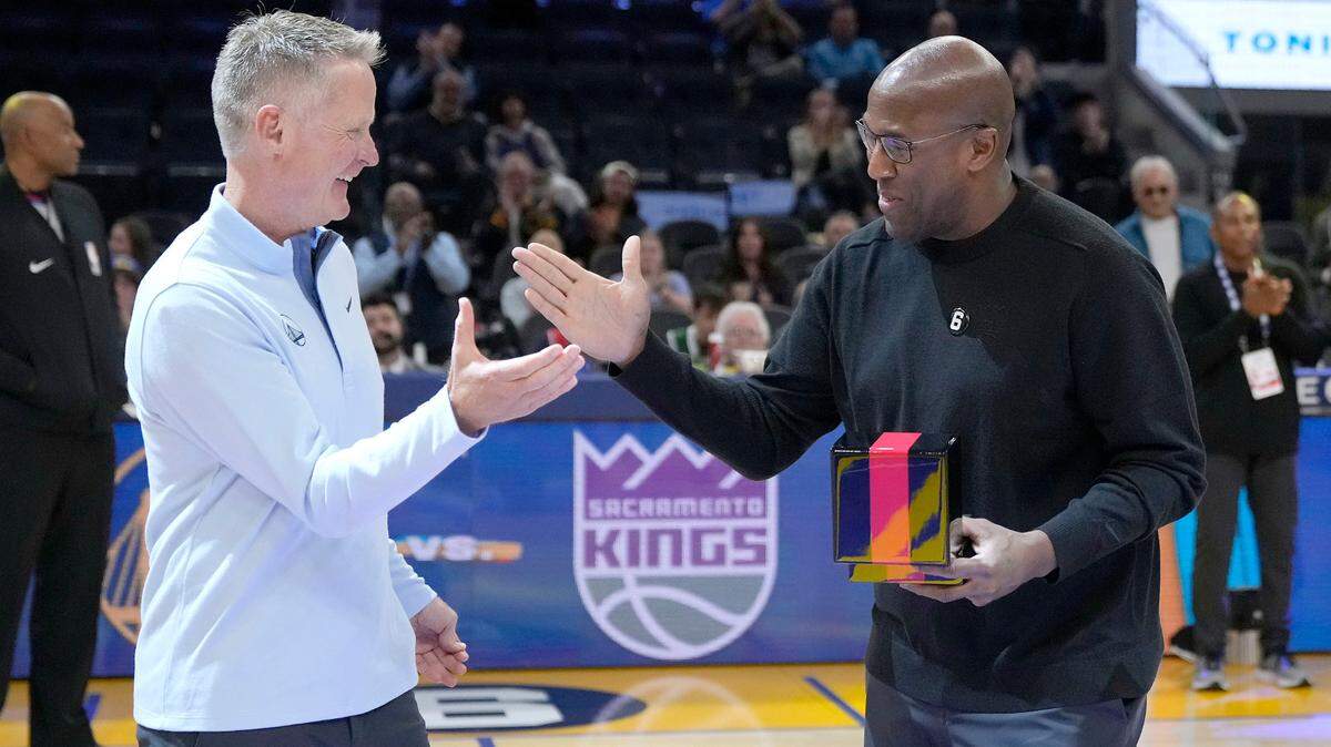 Golden State Warriors head coach Steve Kerr, left, shakes hands with former Warriors assistant coach and Sacramento Kings head coach Mike Brown, right, after Brown was given his 2021-2022 NBA Championship ring before an NBA basketball game between the Warriors and the Kings on Sunday in San Francisco.