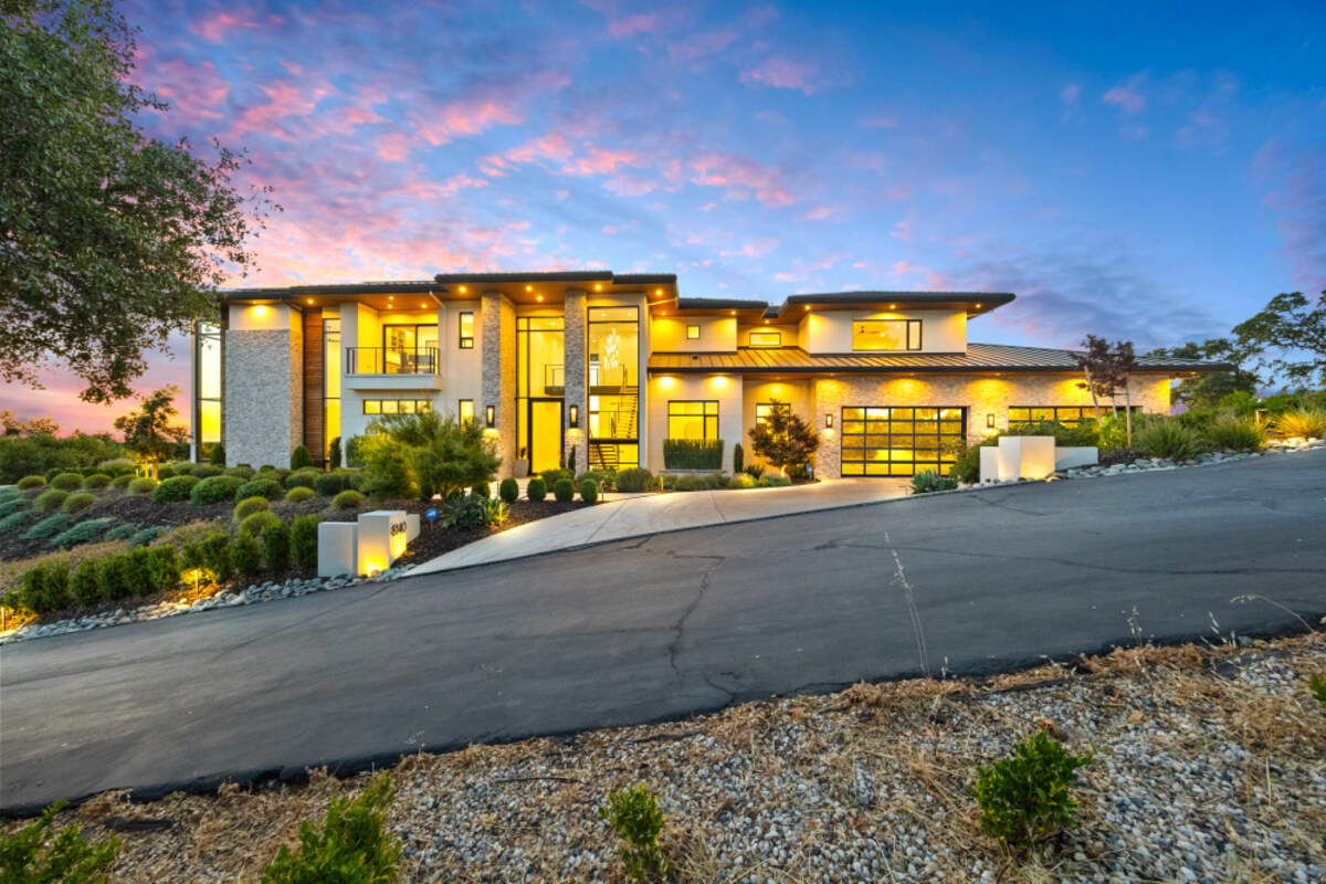 Grand 24-foot floor-to-ceiling windows bathe the Loomis home in natural light, showcasing dramatic architecture, a floating staircase, and a sleek glass catwalk.