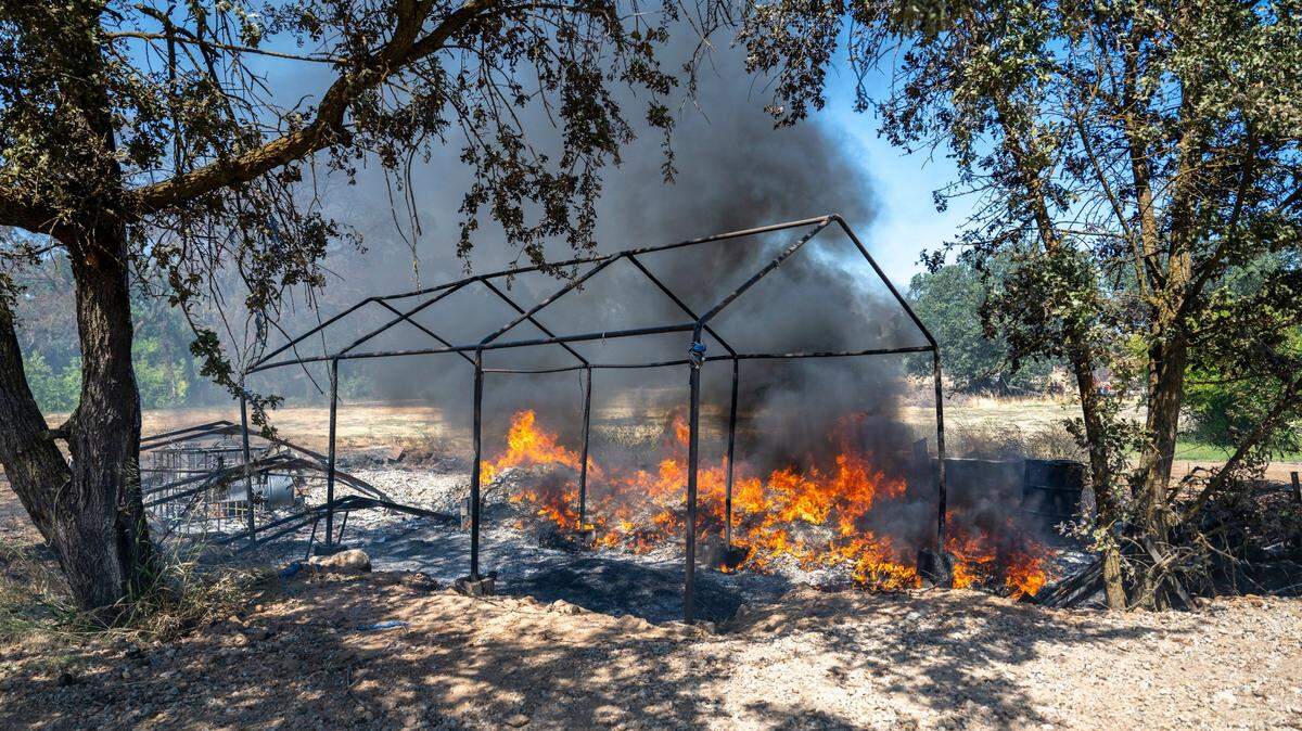 Empty bee hives burn on the Donchenko’s property from a brush fire near Dry Creek Road in Rio Linda on Monday.