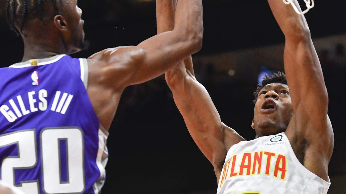 Atlanta Hawks forward De’Andre Hunter (12) shoots as Sacramento Kings forward Harry Giles III (20) defends during the first half of an NBA basketball game Friday, Nov. 8, 2019, in Atlanta. (AP Photo/John Amis)