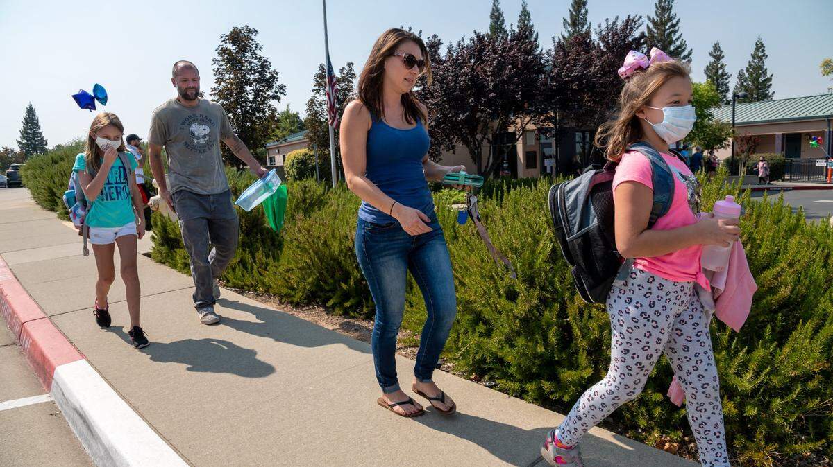 Eleesha Aromin picks up her daughter Rilee, 9, with Mike Bryant and his daughter Alexis, 9, after their first in-class instruction at Sierra Elementary School on Monday, Sept. 21, 2020 in Rocklin. Students across the Rocklin Unified School District returned to in-class instruction on Monday after starting the year with distance learning because of the coronavirus pandemic. Citing COVID concerns, the district did not allow media on campus.