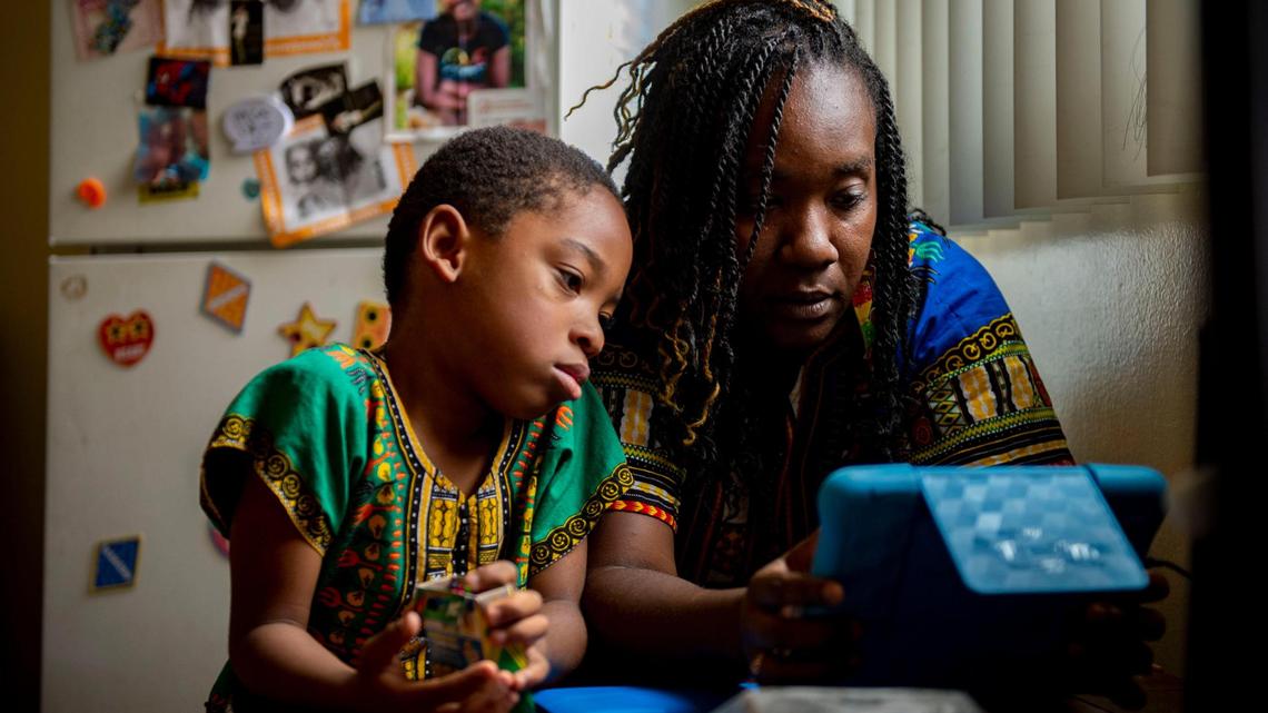 Tulley Smith, 6, a first-grader at Leataata Floyd Elementary School, works with his mom Marcheri Smith on online distance learning in their home in Sacramento on Friday, Oct. 2, 2020. As California reopens and vaccinated people can do more without masks, we can’t forget the lessons we learned about unequal health and education access, writes The Bee’s Editorial Board.