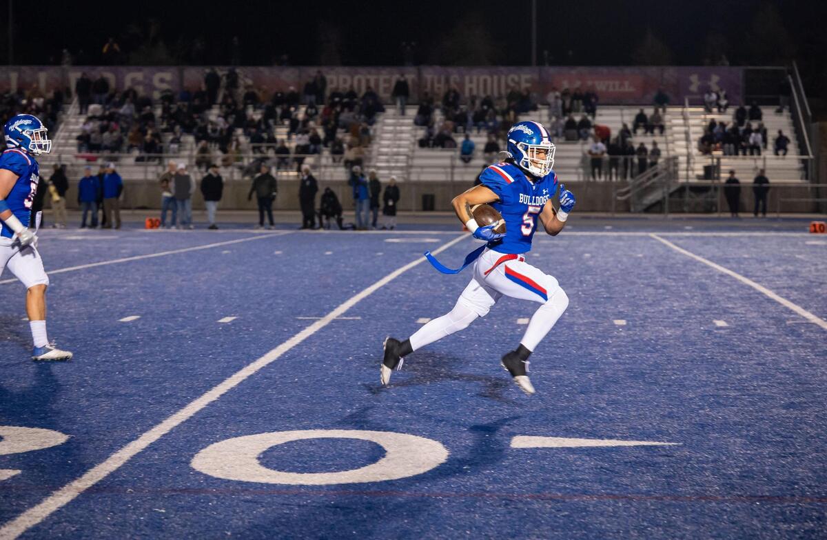 Folsom Bulldogs free safety Greco Carrillo (5) runs for a touchdown to score the first points of the game after helping force a fumble and recovering the ball during the first quarter against De La Salle at the CIF Northern California Regional Championship football game Friday at Folsom High School.
