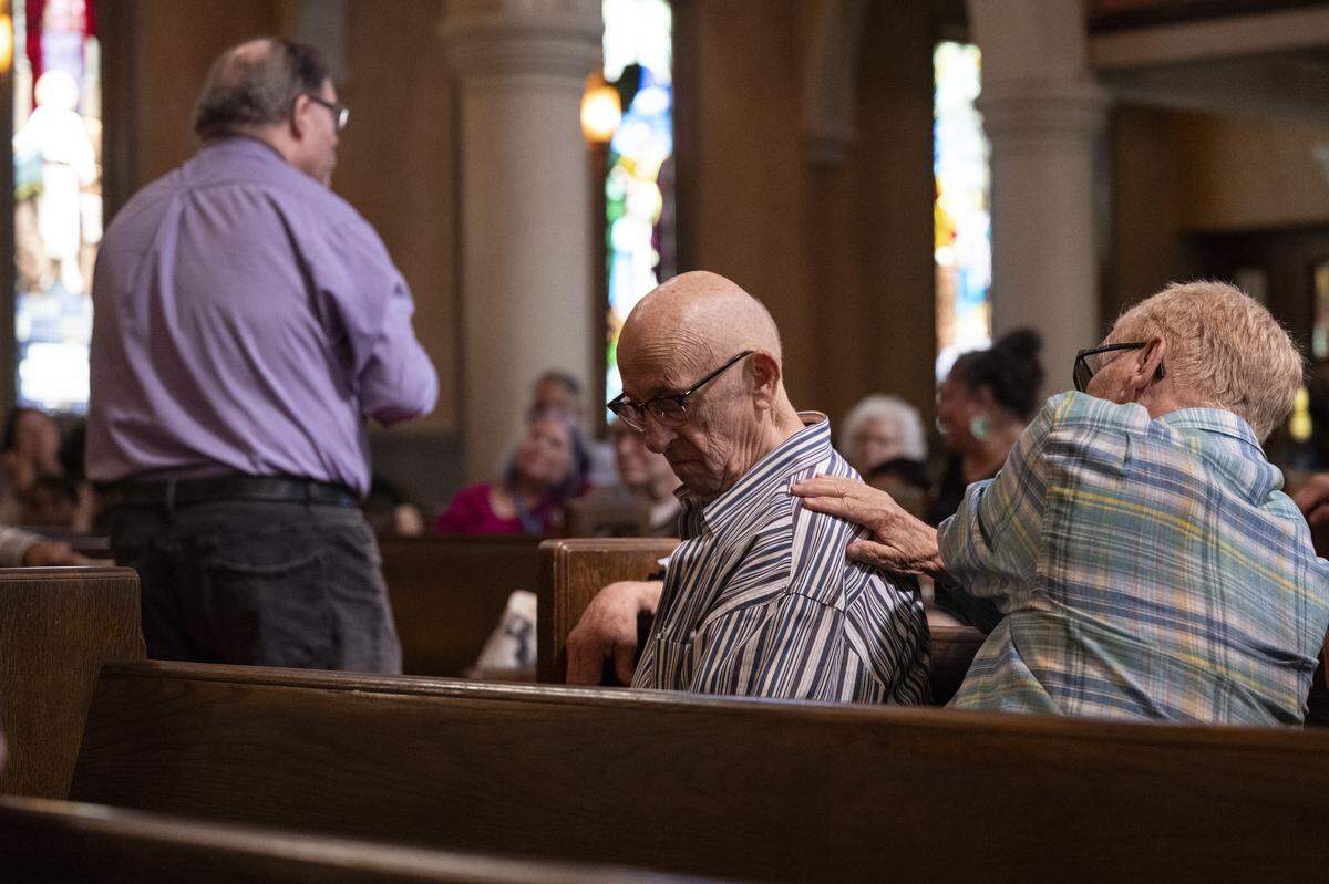 Raymond Graetz and Joseph Lenihan comfort each other during the final service of Pioneer Congregational United Church of Christ at their church on L Street in Sacramento on Sunday, May 31, 2026.
