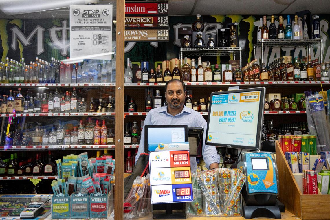 Jas Hundal, owner of Natomas Wine & Spirits, stands behind the counter at his Sacramento store on Wednesday, Aug. 16, 2023, just before he closed the shop for two hours to protest Senate Bill 553. The bill would prohibit employers from maintaining policies that require rank-and-file, non-security personnel to confront suspected active shoplifters.