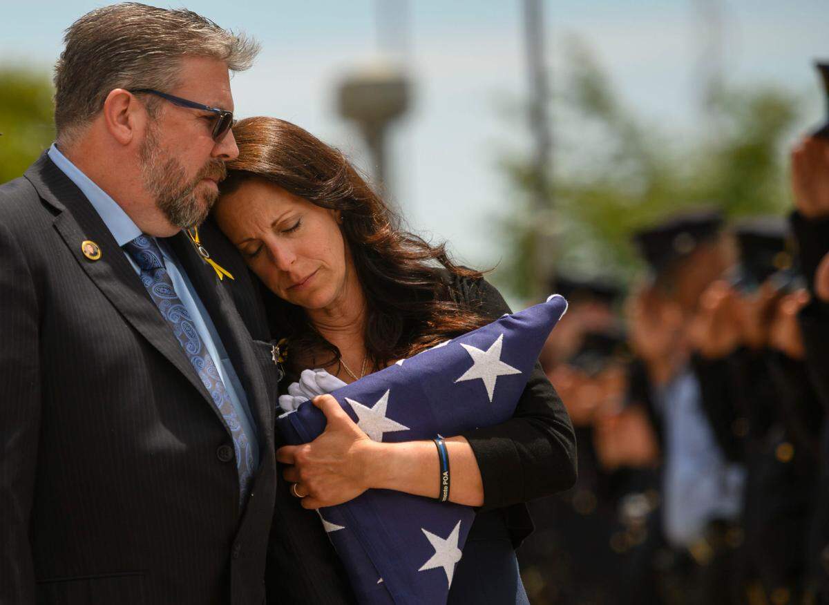 Kelley O’Sullivan leans into her husband Denis while the casket of their daughter, fallen Sacramento Police officer Tara O’Sullivan, is loaded into the hearse following the memorial service for in 2019.