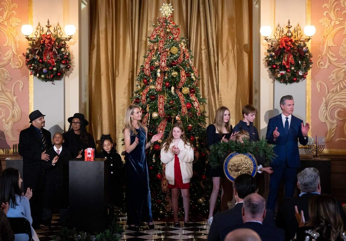 Carter Morris, 9, with his parents Lynne and Karl Morris and sister Samira, listen to the Oakland Interfaith Gospel Choir with Gov. Gavin Newsom, First Partner Jennifer Siebel Newsom and their children during the 93rd annual California Capitol tree lighting ceremony inside the state Capitol on Wednesday.