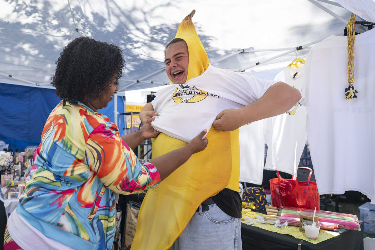 Vendor LaToya Carr, left, helps Patrick Keller, right, put on a shirt that reads ‘Dolce & Banana’ over his banana costume during the Sacramento Banana Festival at William Land Park on Sunday.