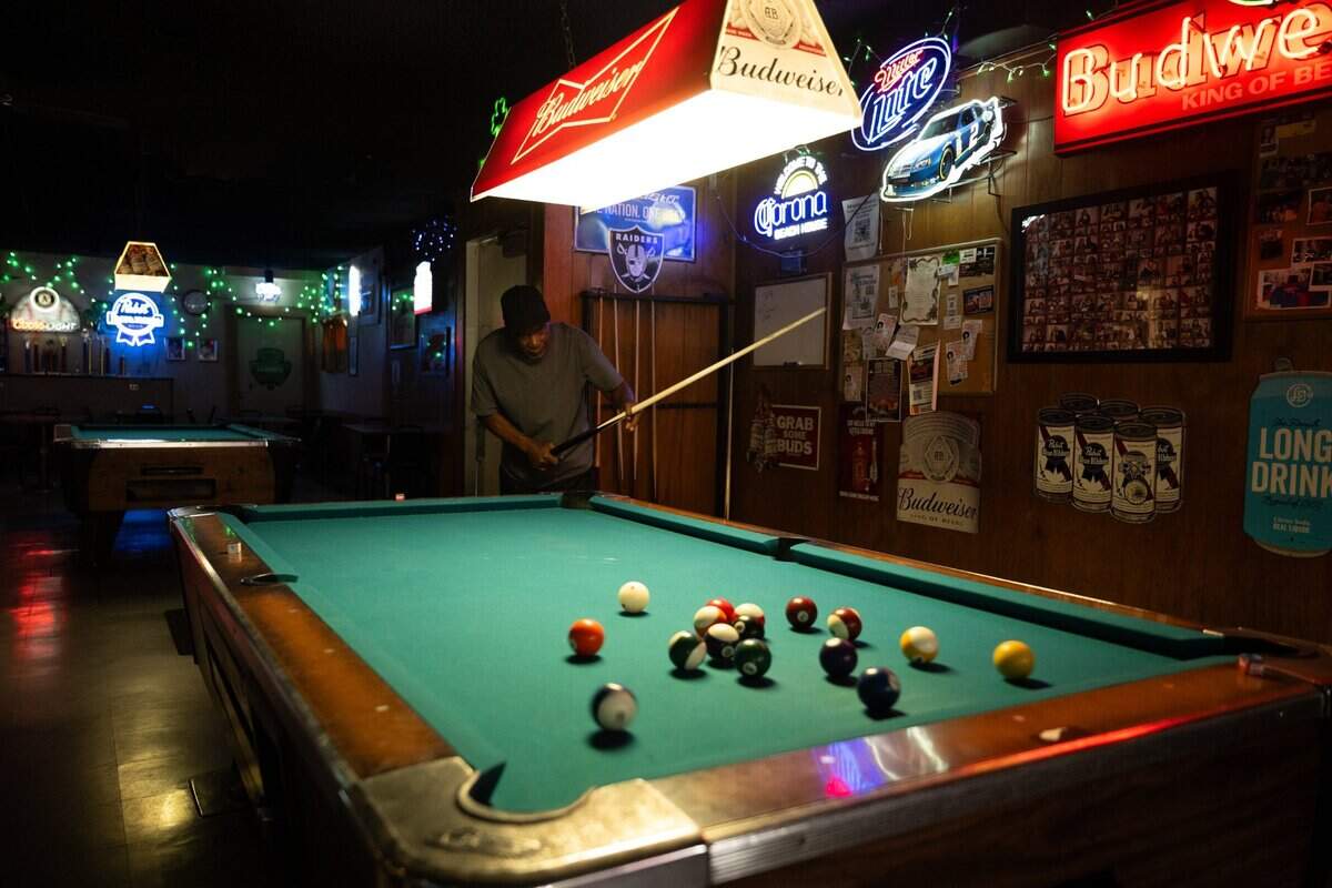 Customer New York plays pool at the Round Corner Tavern in Sacramento earlier this month.