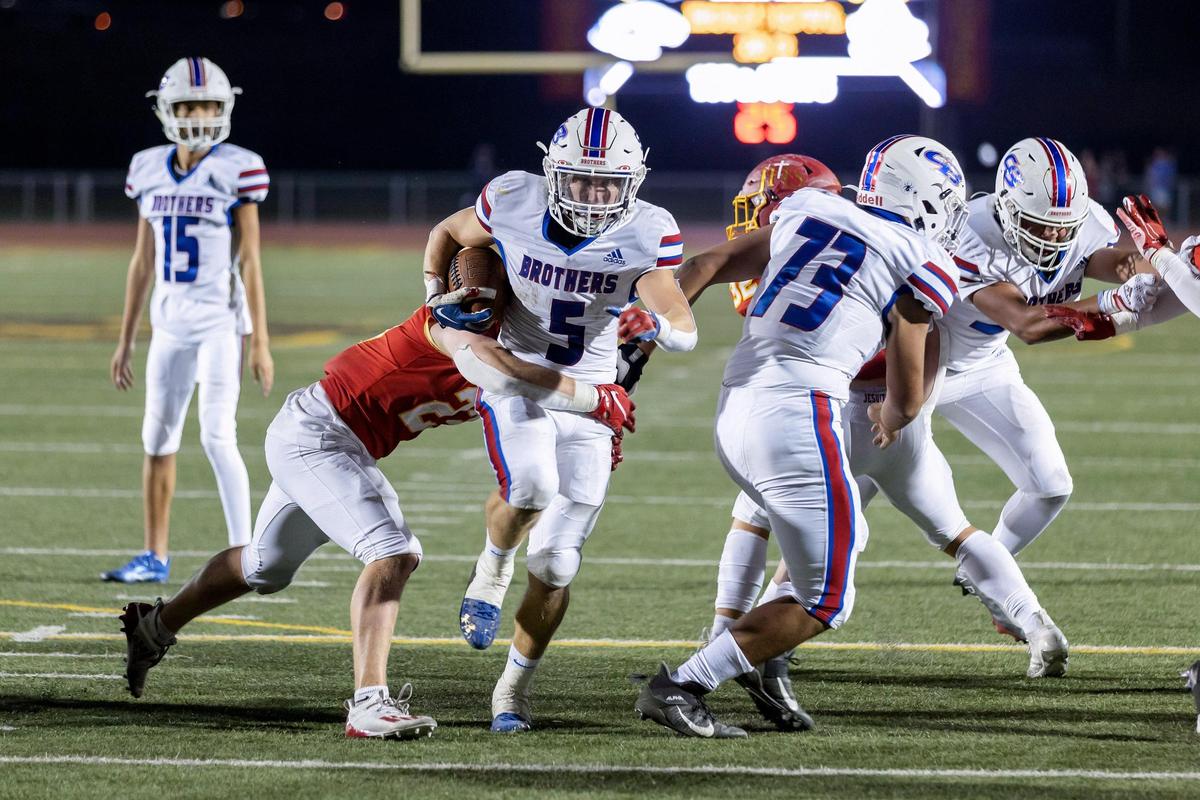 Christian Brothers’ Erik Jensen (5) runs the ball to the second yard line before being tackled by Jesuit’s Tatum Pappas (23) during the second quarter in the Holy Bowl on Saturday, Sept. 10, 2022, at Sacramento City College in Sacramento. The Marauders won 21-7.
