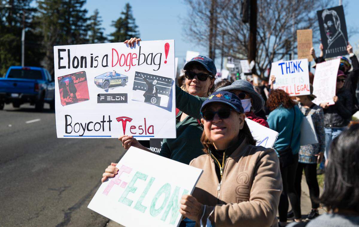 Demonstrators rally against Elon Musk at a Tesla dealership on Arden Way near Sacramento on Saturday, March 8, 2025. More than 100 people lined both sides of street to protest the role of the tech billionaire and Tesla CEO in the Trump administration.