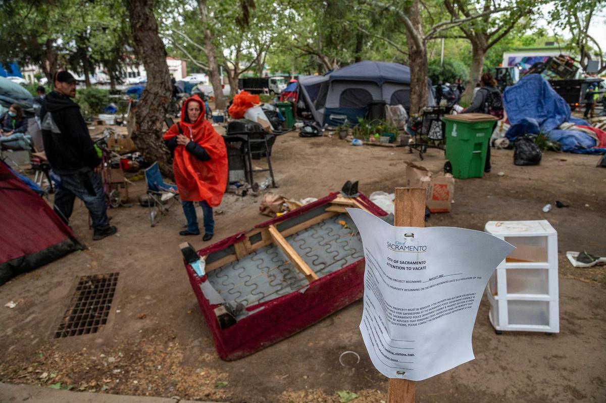 A Sacramento City sign warns homeless residents to vacate “the hill” encampment near Fair Oaks and Howe in April.