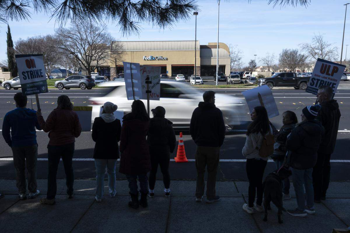 Striking medical workers wave signs outside Kaiser Permanente’s Roseville Medical Center in Roseville on Monday, Jan. 26, 2026.