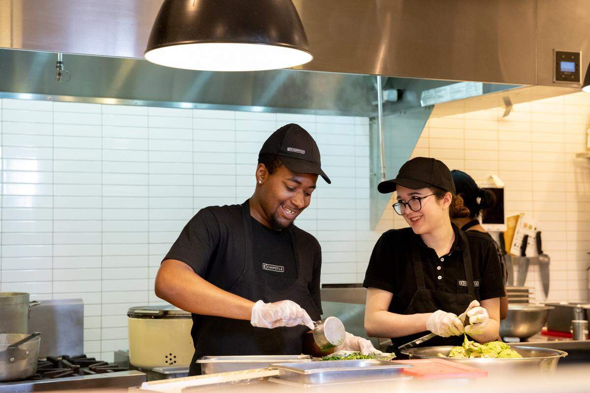 Team members prepare food at Chipotle Mexican Grill.