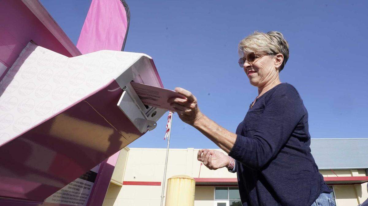 A Sacramento resident casts her primary ballot at a drop-off box in early June.