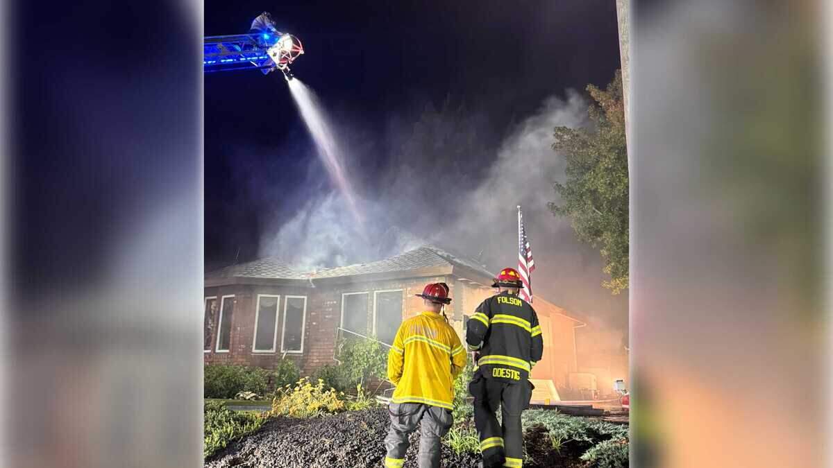 Firefighters attack flames from above using a ladder truck on River Ridge Way in Folsom, Calif., on Monday, Sept. 8, 2025. Authorities say the fire broke out during a standoff with a possibly suicidal person believed to be inside the home.