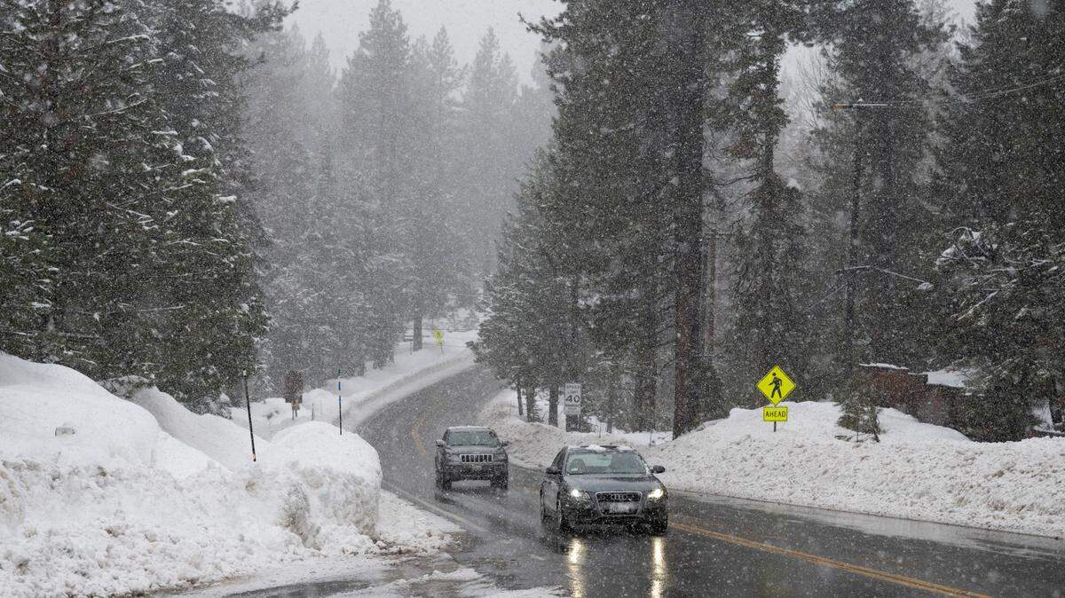 Vehicles move swiftly as snow falls on Highway 89 along the west shore of Lake Tahoe on Thursday, Jan. 5, 2023.
