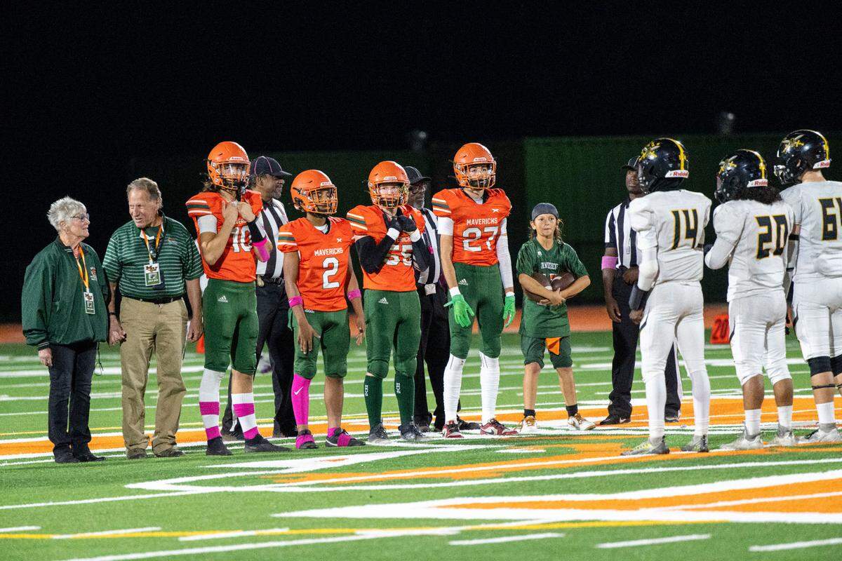 Ron Barney, second from left, a longtime coach at Mesa Verde and current athletic director of the San Juan Unified School District, stands with the team for the pregame handshake on the opening night of their brand-new football field in 2023.
