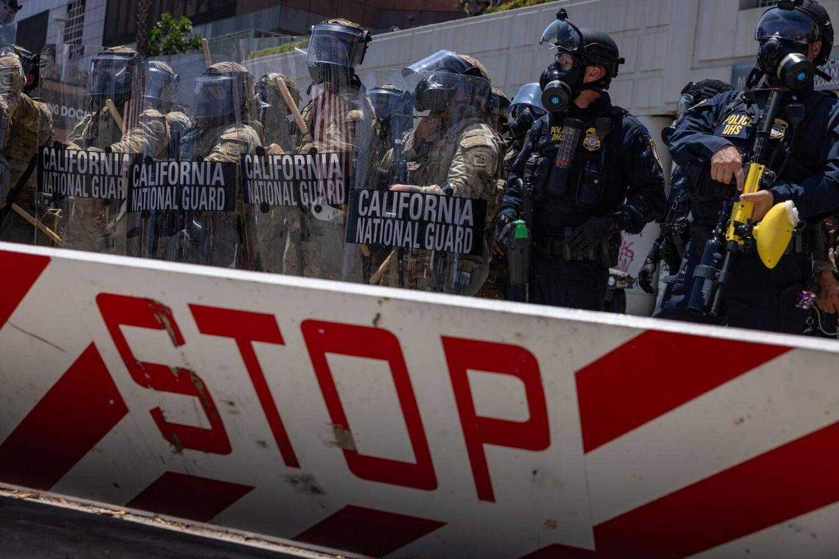California National Guard troops stand outside the Metropolitan Detention Center in downtown Los Angeles on Sunday amid protests against federal immigration raids. The troop presence followed President Donald Trump’s directive to send 4,000 Guard members and 700 Marines to the city over the objections of Gov. Gavin Newsom, who has challenged the legality of the deployment in federal court.