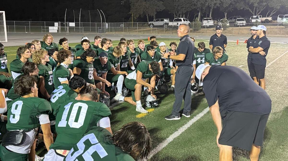 Ponderosa Bruins head coach Davy Johnson speaks to his team Friday after the Bruins defeated the visiting Foothill Mustangs 50-6 in Shingle Springs.