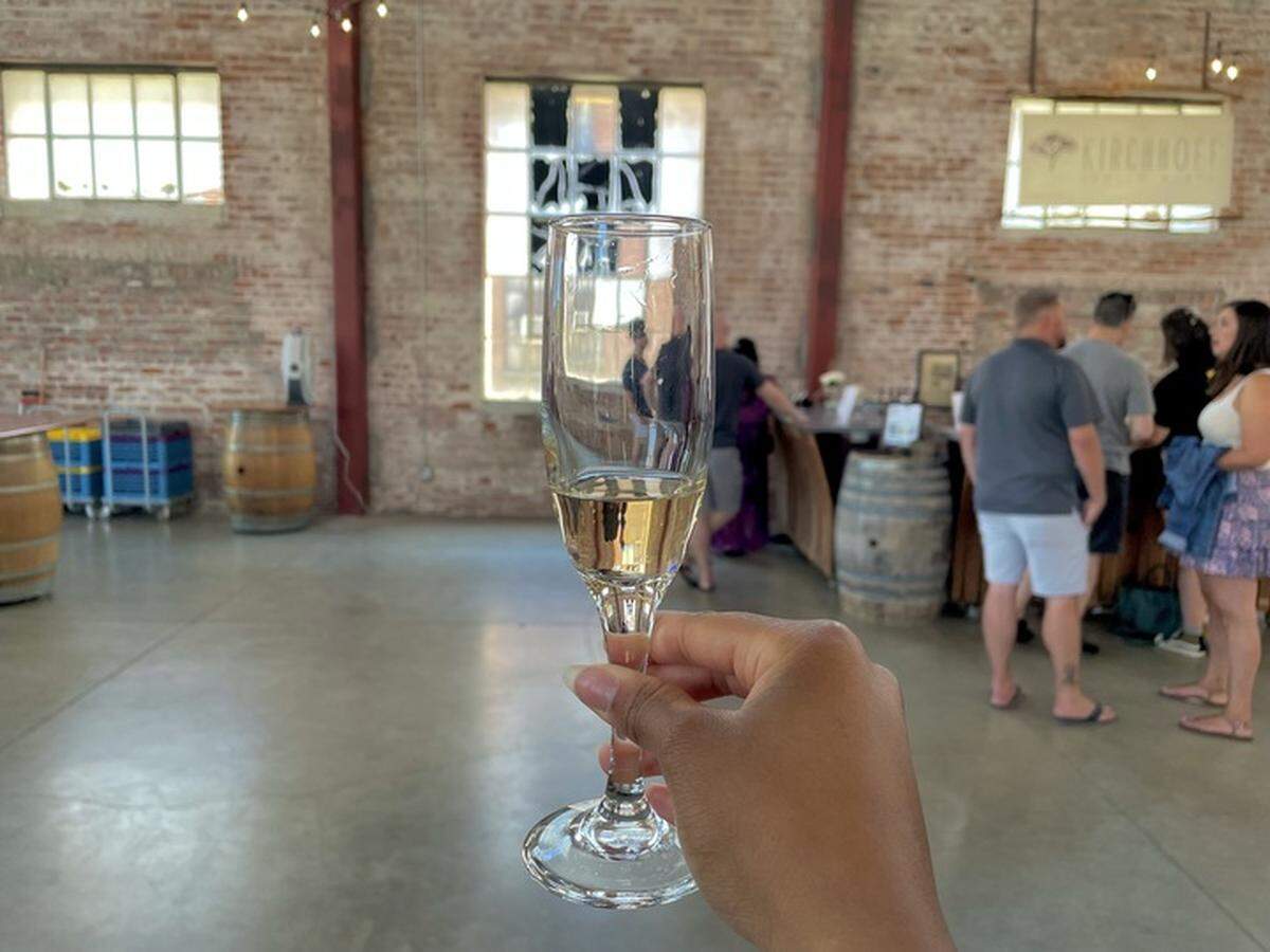 Service journalism reporter Brianna Taylor visits Old Sugar Mill at 35265 Willow Ave., Clarksburg on June 24, 2023, with $25. She sips a sample of peach mango sparkling wine at Bonitata Boutique.