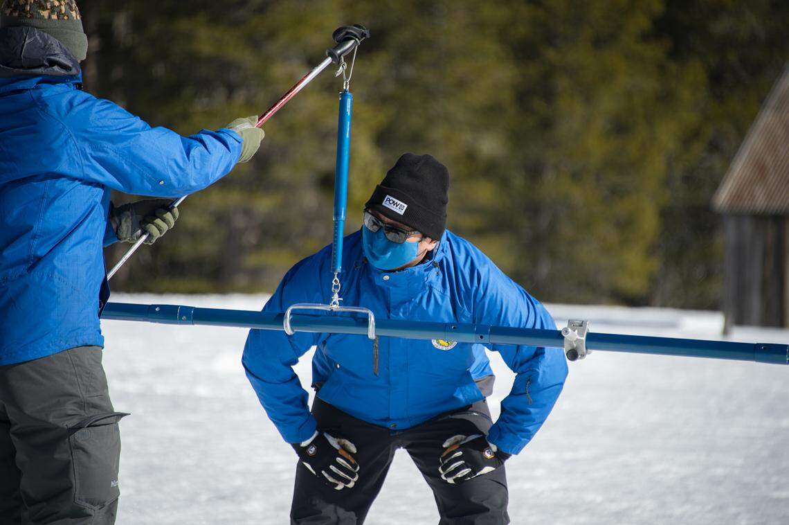 Sean de Guzman, right, manager of snow surveys for the California Department of Water Resources, measures the snowpack for the February snow survey with DWR water resources engineer Anthony Burdock at Phillips Station off Highway 50 on Tuesday.