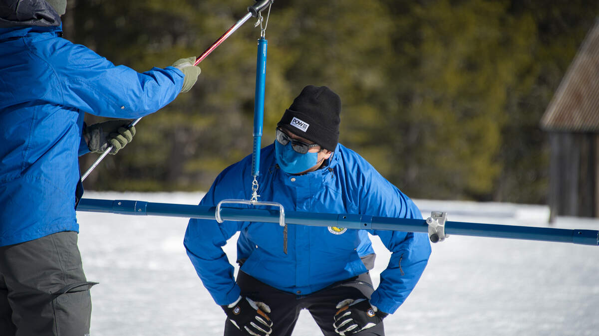Sean de Guzmán, a la derecha, gerente de estudios de nieve para el Departamento de Recursos Hídricos de California, mide el manto de nieve para el estudio de nieve de febrero con el ingeniero de recursos hídricos del DWR, Anthony Burdock, en la Estación Phillips de la Autopista 50 el martes 1º de febrero de 2022.