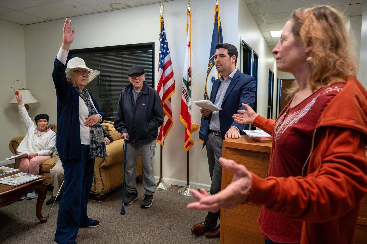 Chris Hayashi, right, of Placerville joins a group from Indivisible El Dorado to speak with Matt Reed, a district chief of staff at Congressman Tom McClintock’s office, second from right, in El Dorado Hills on Friday. “Raise your hands if we are all in favor of government efficiency but want transparency,” said Hayashi.