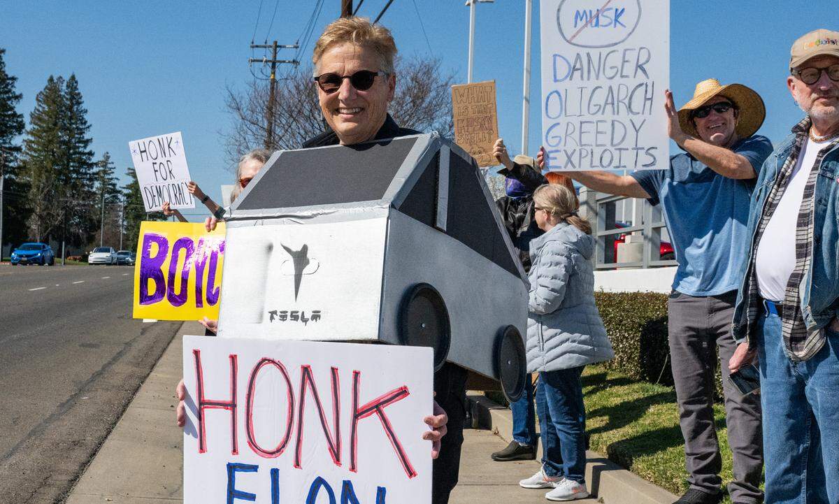 Protester Jennifer Hogan, wearing a Tesla Cybertruck costume with the word “swasticar” emblazoned on the back, demonstrates against Elon Musk at a Tesla dealership on Arden Way near Sacramento on Saturday, March 8, 2025. “As good as Tesla’s first mission was, it’s now become soiled,” she said.