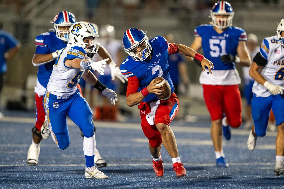Folsom Bulldogs quarterback Ryder Lyons (3) scrambles and evades Serra Padres defensive lineman Silas Adkins (98) before throwing a desperation pass in the end zone on the game’s final play on Friday at Folsom High School.