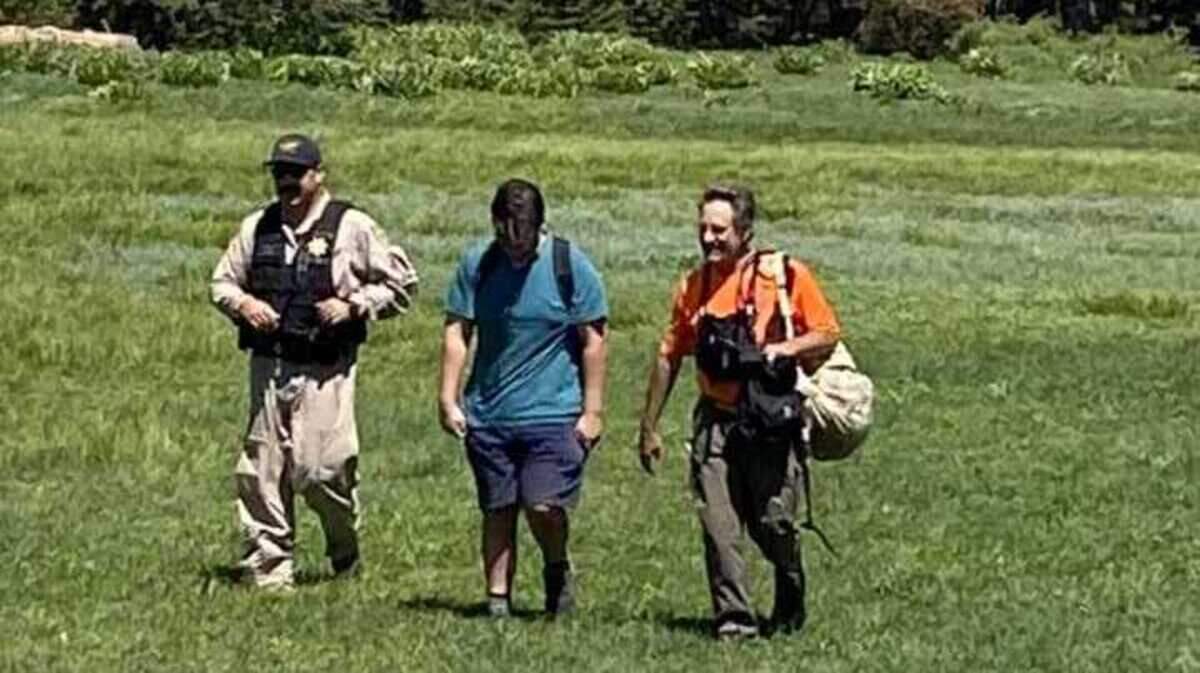 Rescue personnel walk with a hiker who was located Saturday, July 15, 2023, after he got lost and spent the night in the woods in Amador County near Silver Lake.