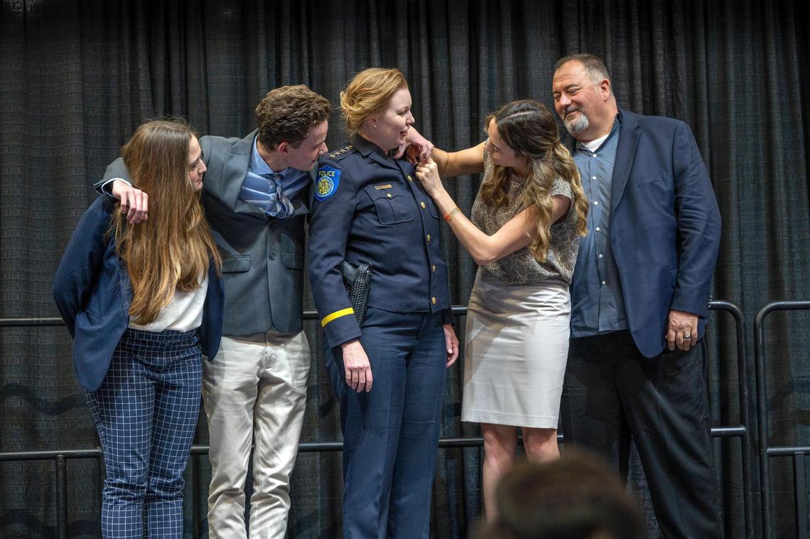 Sacramento Police Chief Kathy Lester has her badge adjusted by daughter Jacklyn, as her children Hannah, left, son Liam, and husband Keith Hughes watch during her swearing in ceremony at Golden 1 Center in Sacramento in 2022.