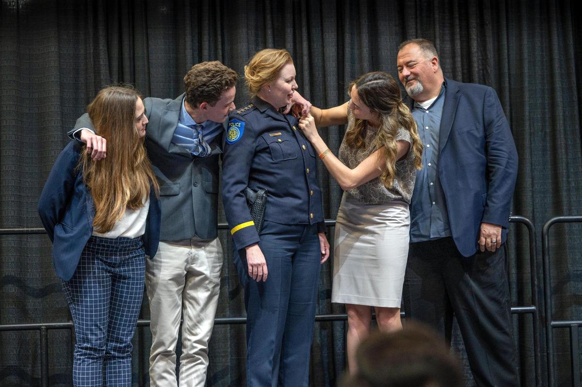 Sacramento Police Chief Kathy Lester has her badge adjusted by daughter Jacklyn, as her children Hannah, left, son Liam, and husband Keith Hughes watch during her swearing-in ceremony at Golden 1 Center on Thursday.
