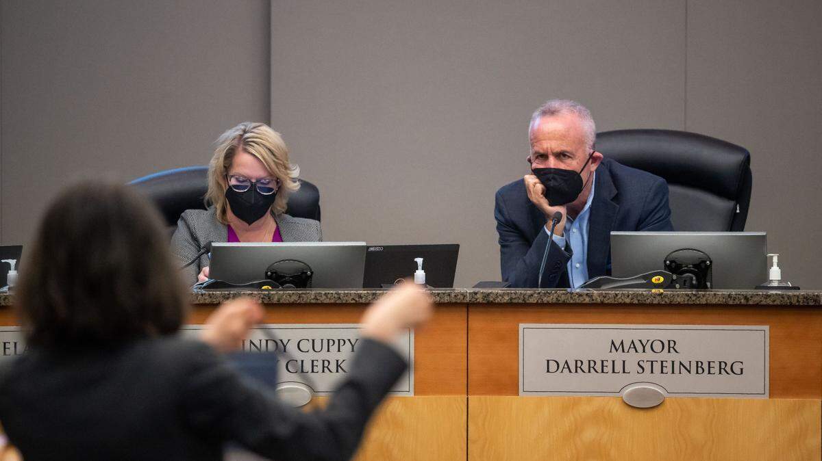 Mayor Darrell Steinberg, right, listens to Jennifer Venema, the city’s climate action lead, during the Sacramento City Council meeting at City Hall on Tuesday, the first meeting open to public attendance since the beginning of the COVID-19 pandemic. Clerk Mindy Cuppy, sits on the dais next to Steinberg. Much of the meeting and public comment focused on the city’s climate goals.