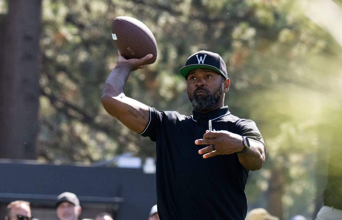 Hall of Fame NFL cornerback Charles Woodson passes a football to a fan during the final day of the American Century Championship celebrity golf tournament at Edgewood Tahoe Resort in Stateline, Nev., on Sunday, July 13, 2025.