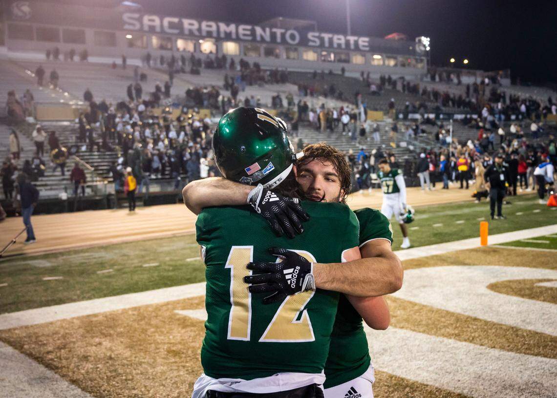 Sacramento State Hornets running back Cameron Skattebo (4), right, hugs quarterback Jake Dunniway (12) as they leave the field after their close 66-63 loss to University of the Incarnate Word (Texas) in the NCAA college football FCS playoffs quarterfinal game Friday, Dec. 9, 2022, at Hornet Stadium in Sacramento.