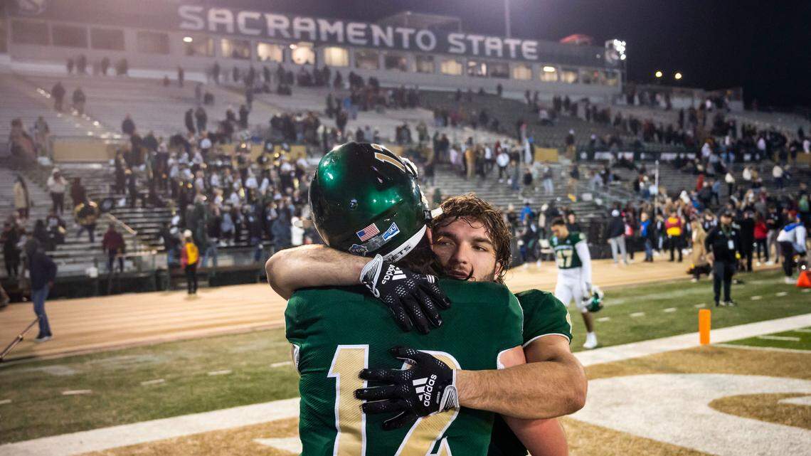 Sacramento State Hornets running back Cameron Skattebo (4), right, hugs quarterback Jake Dunniway (12) as they leave the field after their close 66-63 loss to University of the Incarnate Word (Texas) in the NCAA college football FCS playoffs quarterfinal game Friday, Dec. 9, 2022, at Hornet Stadium in Sacramento.