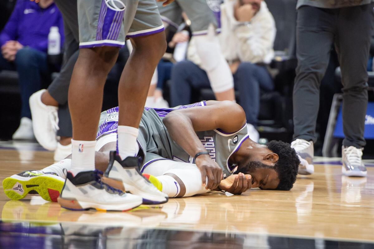 Sacramento Kings forward Chimezie Metu (7) goes down grabbing his knee during the first half but eventually walks off the court to the locker room in the NBA basketball game against the Philadelphia 76ers on Saturday, Jan. 21, 2023, at the Golden 1 Center in Sacramento. The 76ers won 129-127.