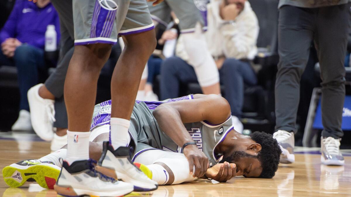 Sacramento Kings forward Chimezie Metu (7) goes down grabbing his knee during the first half but eventually walks off the court to the locker room in the NBA basketball game against the Philadelphia 76ers on Saturday, Jan. 21, 2023, at the Golden 1 Center in Sacramento. The 76ers won 129-127.