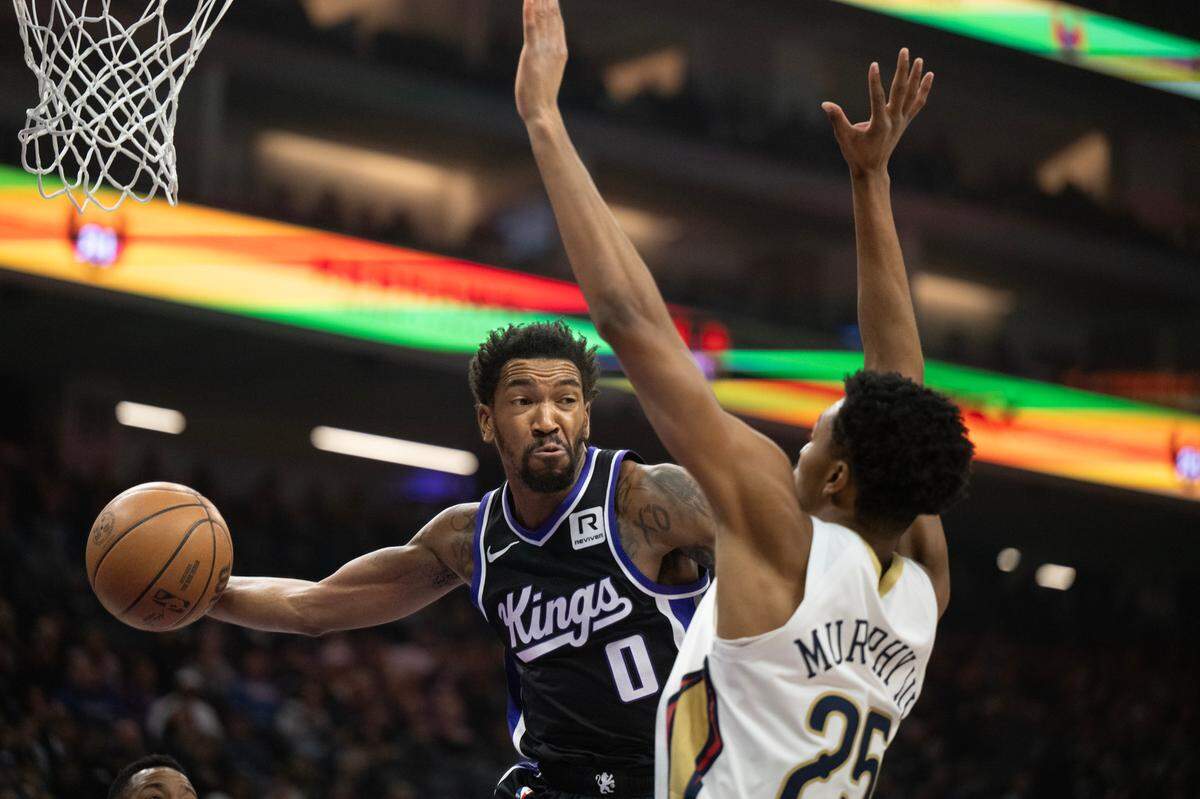Sacramento Kings guard Malik Monk (0) makes a pass past New Orleans Pelicans guard Trey Murphy III (25) in the first half on Saturday, Feb. 8, 2025 at Golden 1 Center.