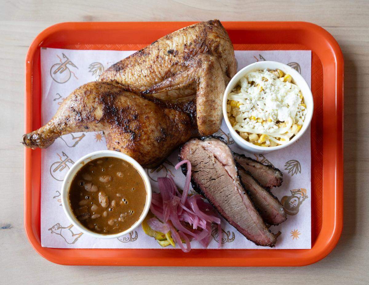 Smoked chicken and brisket with a side of beans and elote cup at Slow & Low Smokehouse’s soft opening in Elk Grove on Wednesday.