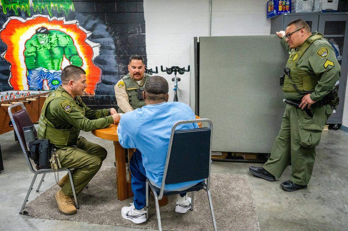 Salinas Valley State Prison Correctional officers Edgar Martinez, left, and Ricardo Garcia, center, play dominoes under the watchful eye of Sgt. Danny Delgadillo, right, with an at-risk Level 4 inmate at Salinas Valley State Prison in March. The program, part of the California Model, encourages inmates and security guards to build deeper connections to help prevent violence in the prison.