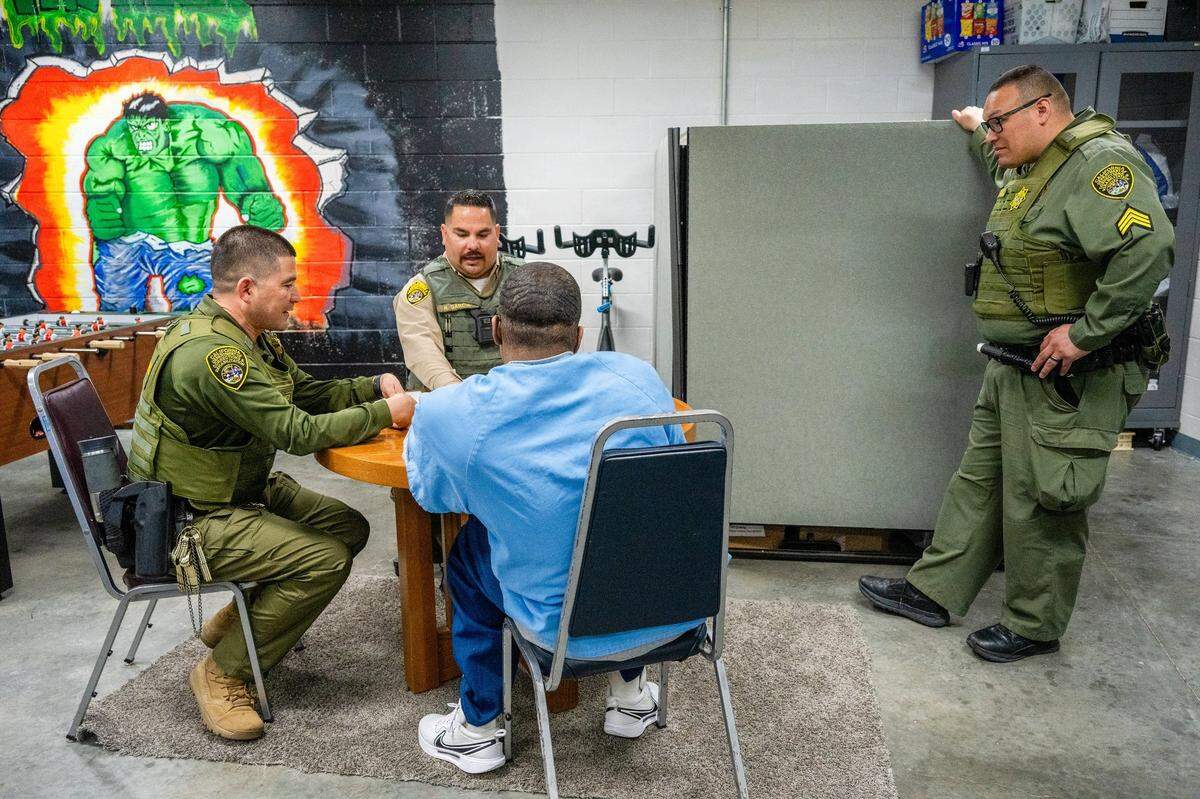 Salinas Valley State Prison Correctional officers Edgar Martinez, left, and Ricardo Garcia, center, play dominoes under the watchful eye of Sgt. Danny Delgadillo, right, with an at-risk Level 4 inmate at Salinas Valley State Prison in March. The program, part of the California Model, encourages inmates and security guards to build deeper connections to help prevent violence in the prison.
