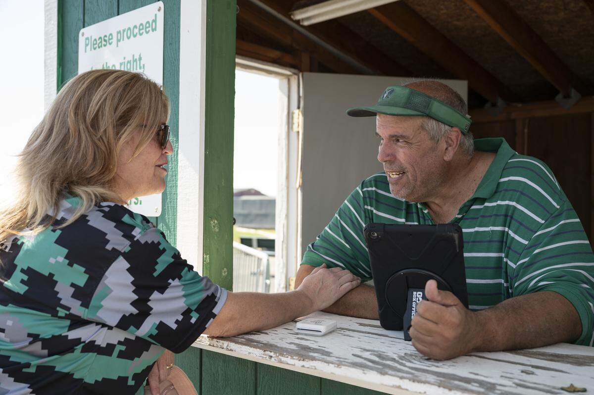 Scott Stacey, right, chats with fans as he sells tickets for the Dixon High School varsity football game in Dixon on Saturday.