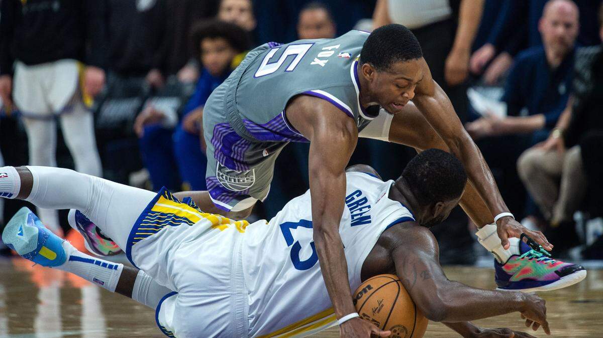 Sacramento Kings guard De’Aaron Fox (5) fights for the ball and is called for a foul against Golden State Warriors forward Draymond Green (23) during Game 5 of the first-round NBA playoff series at Golden 1 Center on Wednesday.