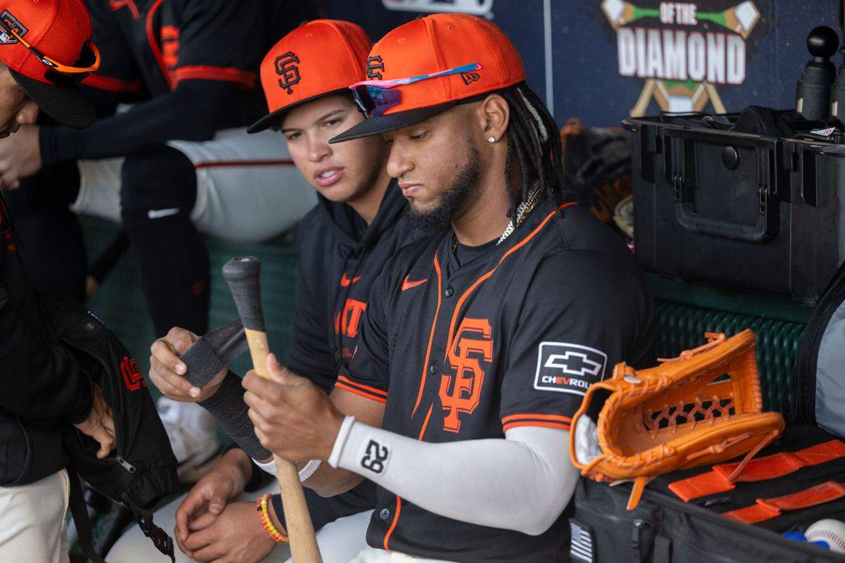 Giants outfielder Luis Matos, right, tapes a bat in the dugout as the San Francisco Giants play the Sacramento River Cats in an exhibition game Sunday.